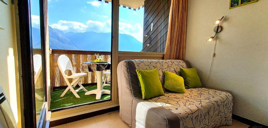 Cette chambre dispose d'un canapé et d'un balcon avec une table. dans l'établissement Résidence Relais - Appartement 6 couchages vue montagne à Réallon 126R MAE-8961, à Réallon