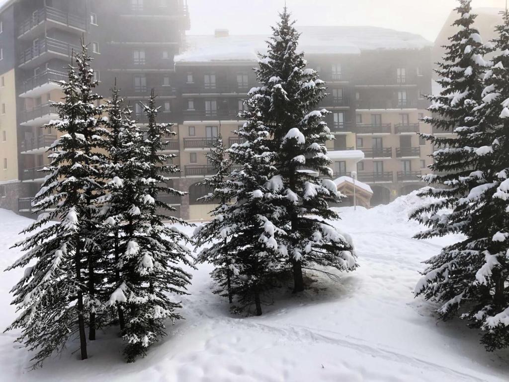 un groupe d'arbres recouvert de neige devant un bâtiment dans l'établissement Résidence Clarines - Charmant studio pour 5 pers. à Risoul 1850 MAE-6951, à Risoul