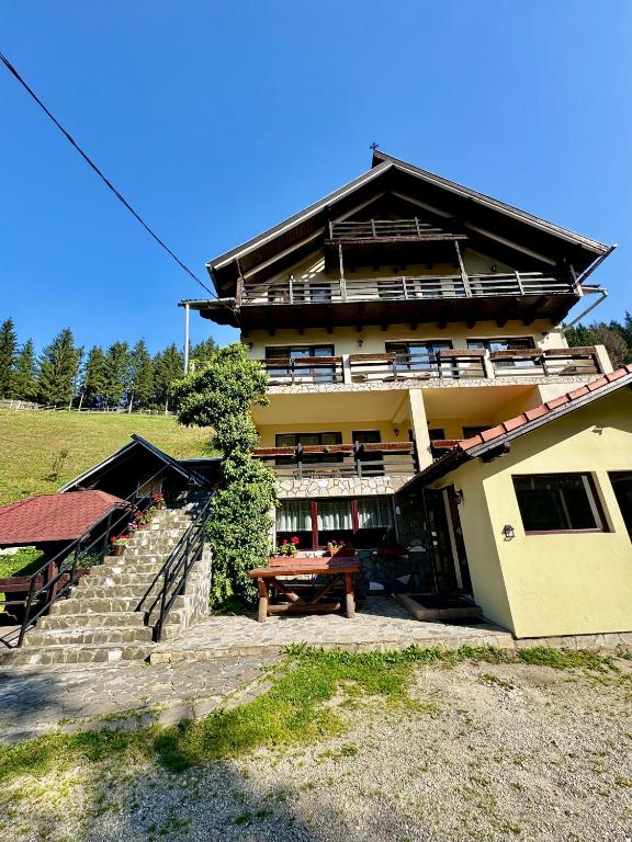 a building with a picnic table in front of it at Crăiasa 2 in Moieciu de Sus