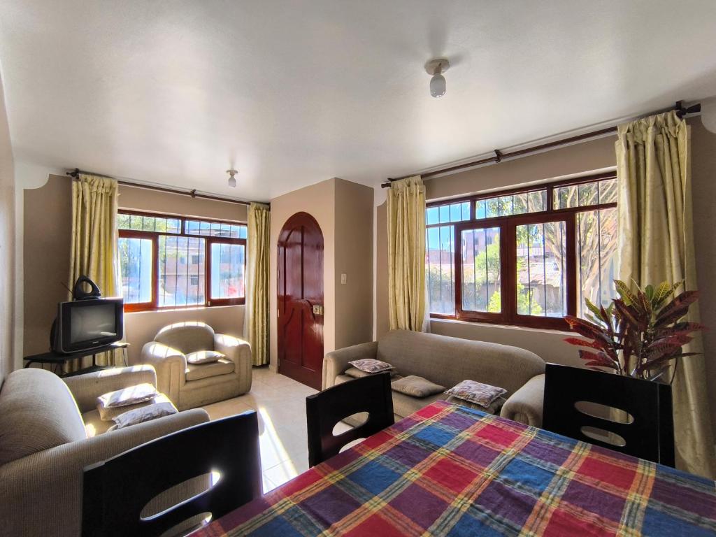 a living room with a bed and a couch and a tv at Casa Waraq in Huaraz