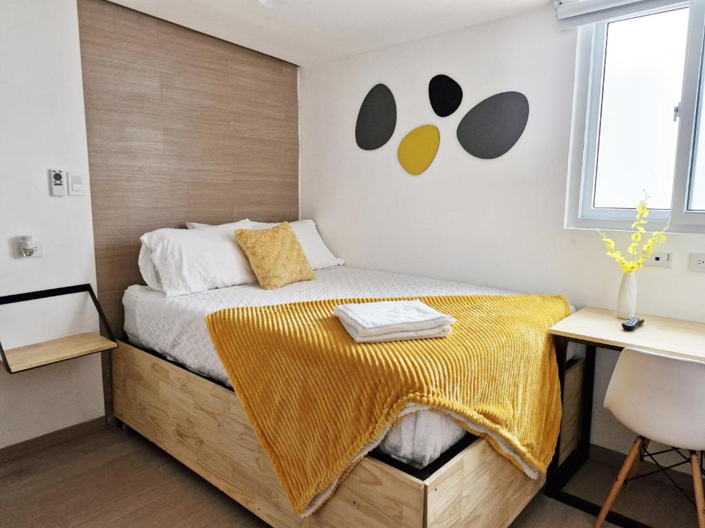 a bedroom with a bed with a yellow blanket on it at Moderna y Relajante Cerca CC Miraflores H2 in El Rodeo