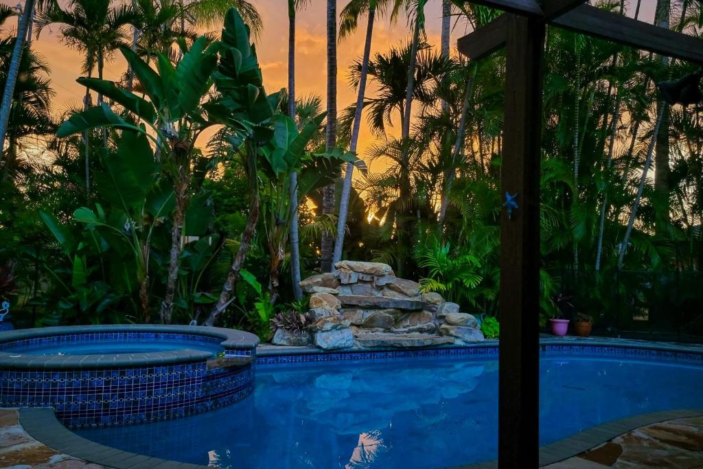 ein Swimmingpool mit Palmen im Hintergrund in der Unterkunft Coastal Paradise Getaway in Cape Coral