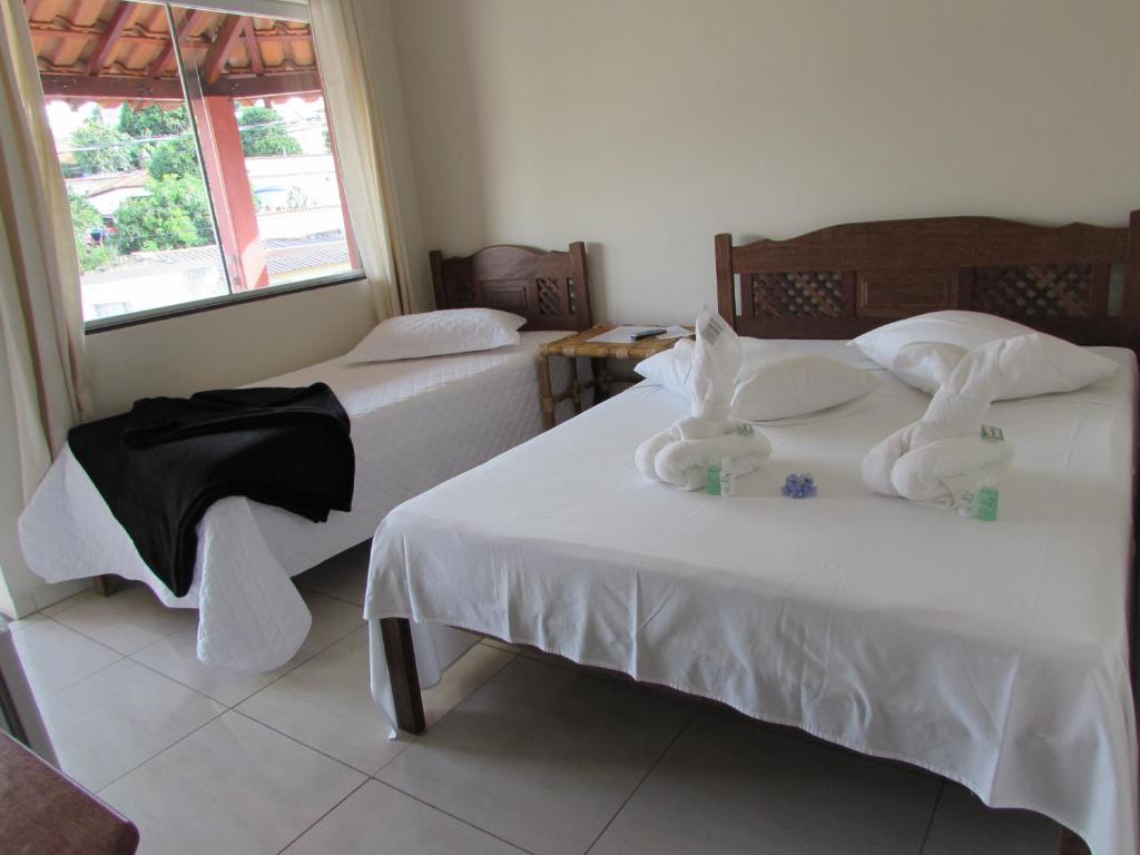 a bedroom with two beds with towels on them at Pousada Canto Do Aconchego in Carrancas