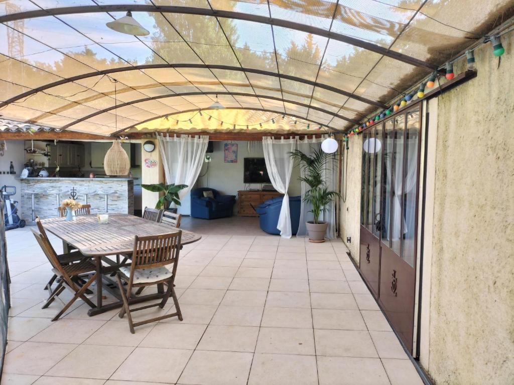 a patio with a table and chairs and a ceiling at le 1387 l'étape en Provence in Plan-dʼOrgon