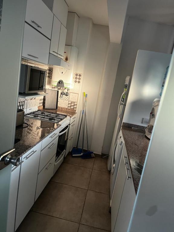 a kitchen with white cabinets and a stove top oven at Scout Apartament in Pilar