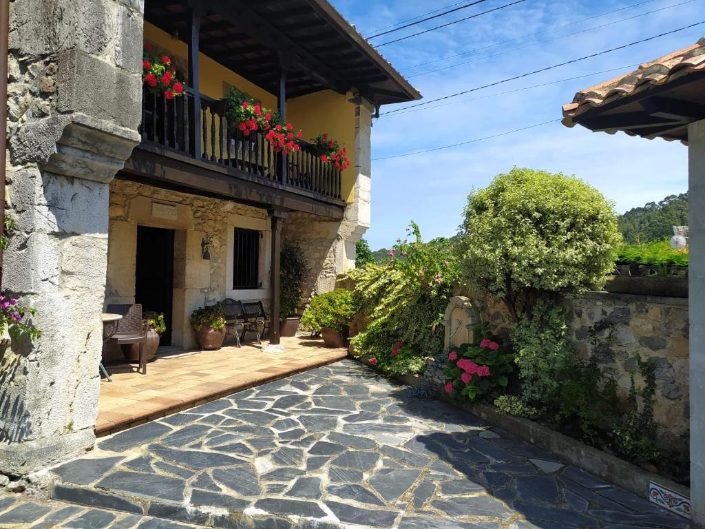 a courtyard of a house with flowers on a balcony at Gran Pedroso de Llanes in Llanes