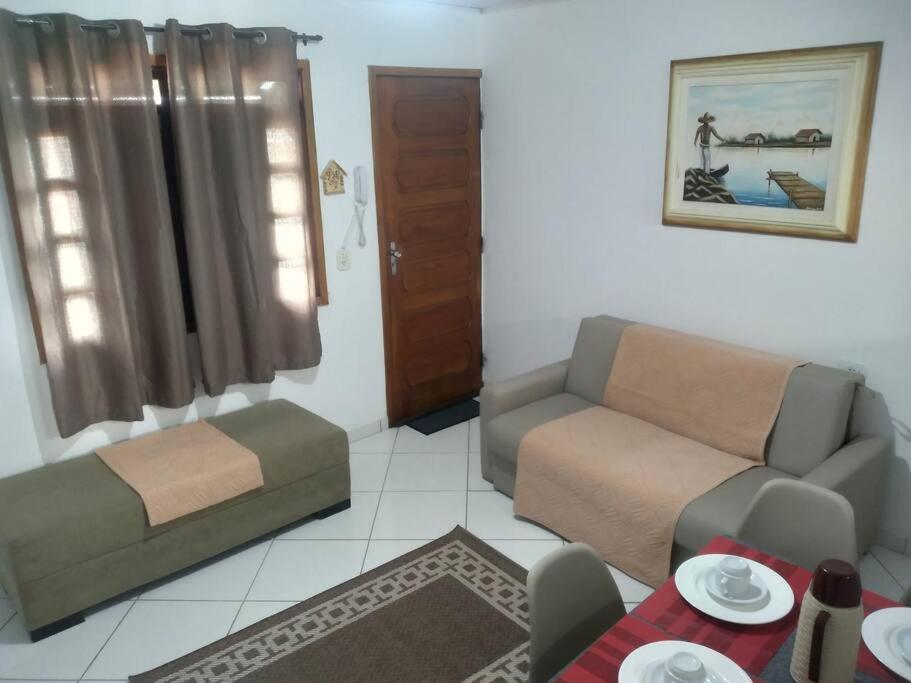 a living room with a couch and a table at Apê 05 confortável perto de tudo in Vitória da Conquista