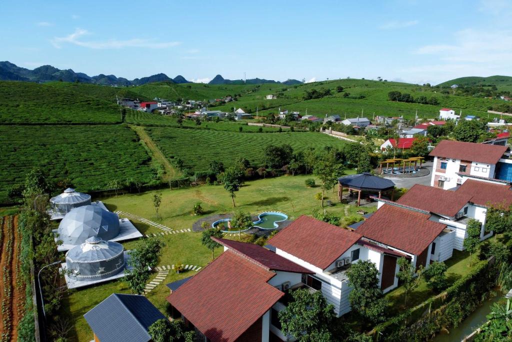 木州县Emopea Moc Chau的享有小村庄的空中景色,设有农场