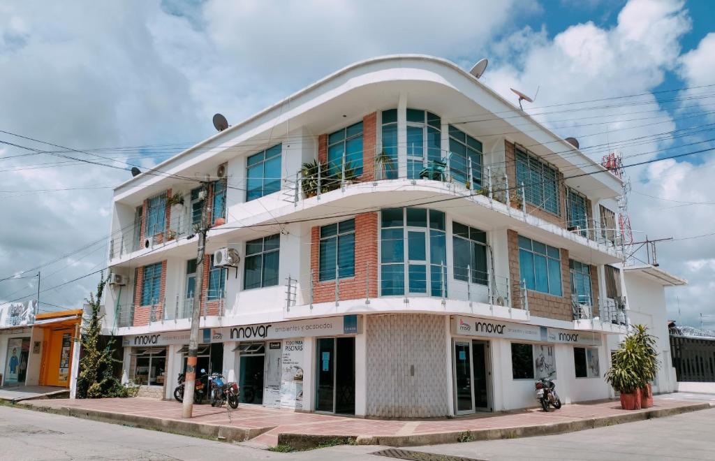 a large white building with windows on a street at 2325 Apartaestudios in Arauca
