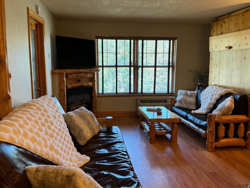 Una sala de estar con un sofá y una chimenea. en North Ridge Mountainside Condo, en Biwabik