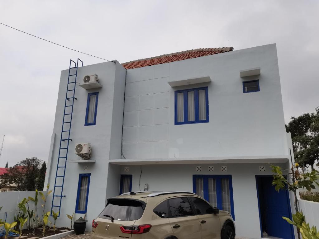 un coche aparcado delante de un edificio blanco en ZG Villa Batu, en Tlekung