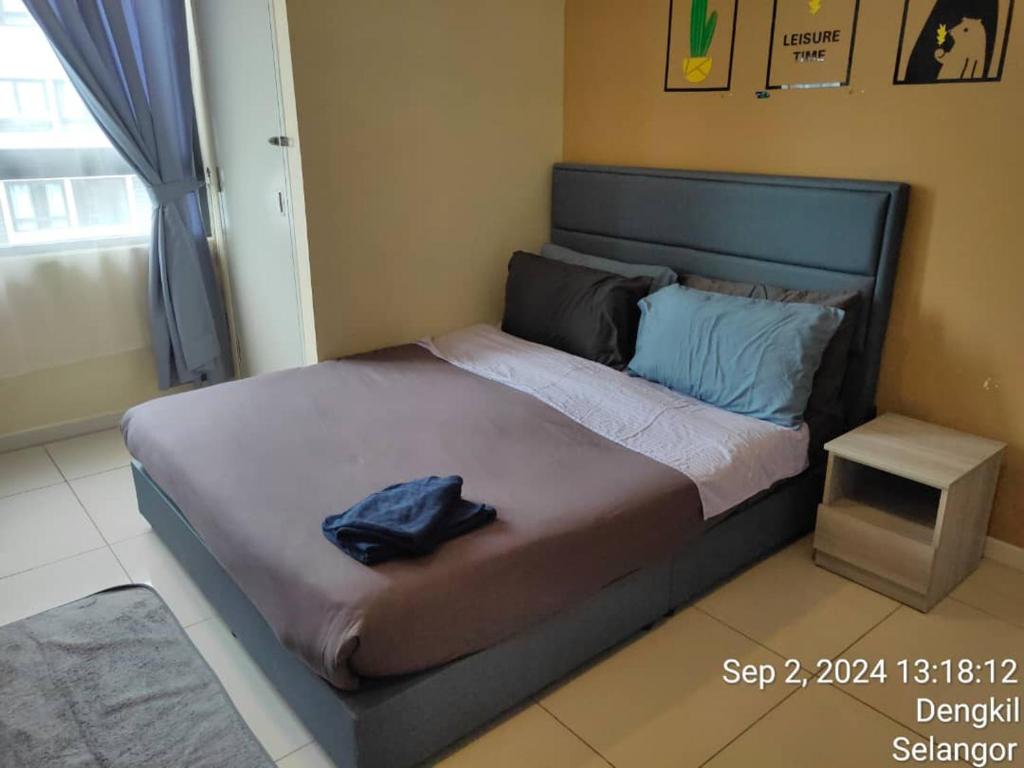 a bed in a bedroom with a blue shirt on it at Happy Family Horizon Suite - near Xiamen-KLIA Netflix in Kampong Melot