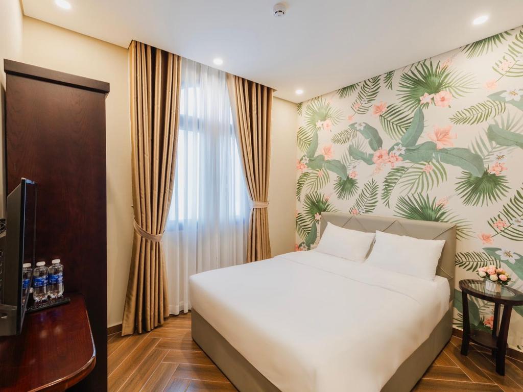 - une chambre avec un lit blanc et un papier peint floral dans l'établissement Tropical Sea Phu Quoc non-sleep, à Duong Dong