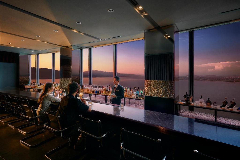 a bar with people sitting at a bar with a view at Lake Biwa Otsu Prince Hotel in Otsu