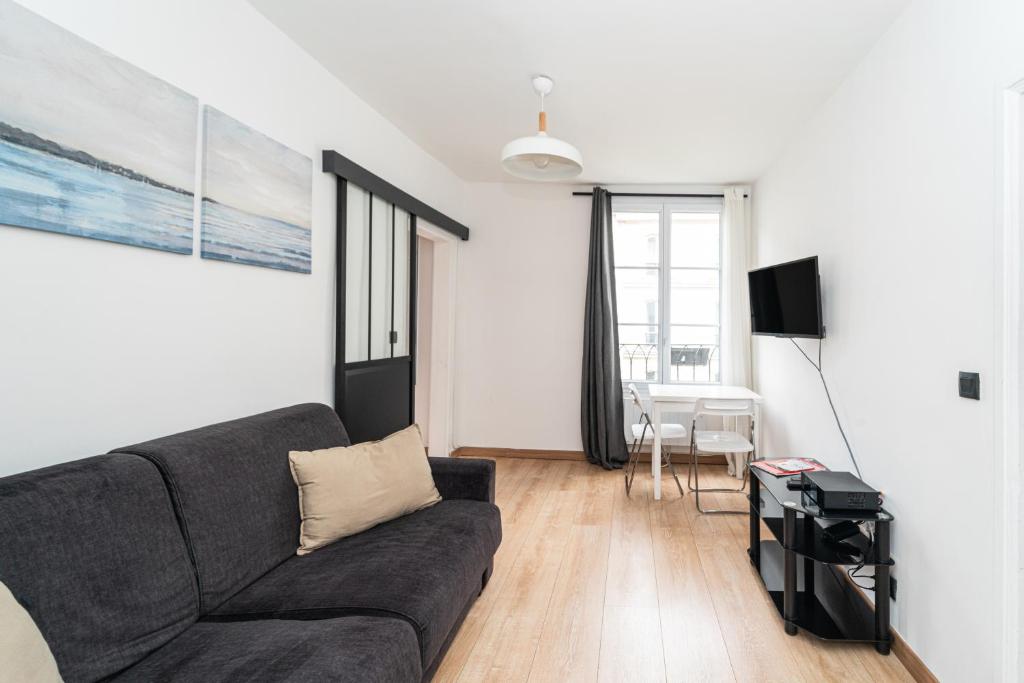 un salon avec un canapé et une table dans l'établissement Charmant 2 pièces à 2 pas du Marais, à Paris