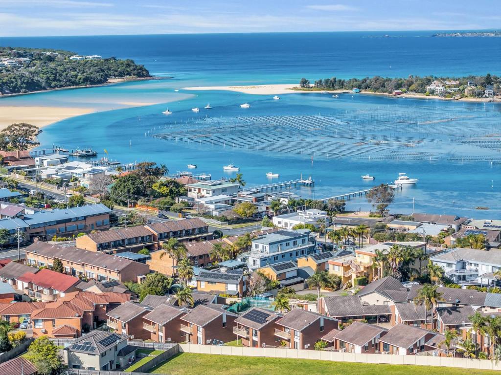 an aerial view of a coastal town with a harbor at Anchorbell Apartments Merimbula in Merimbula