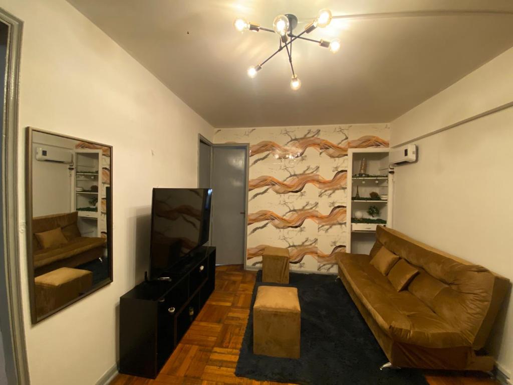 una sala de estar con un sofá y un televisor en CASA ROMÁN Departamento en Providencia para 3 personas, en Santiago