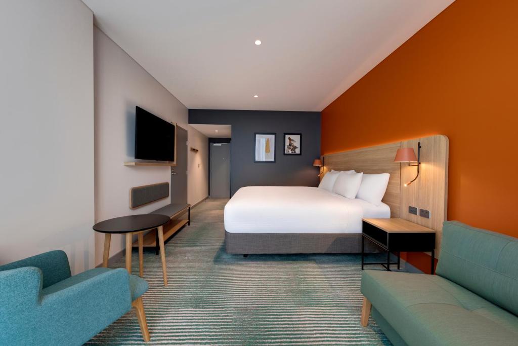 a hotel room with a bed and a couch at Travelodge Hotel Hurstville Sydney in Sydney
