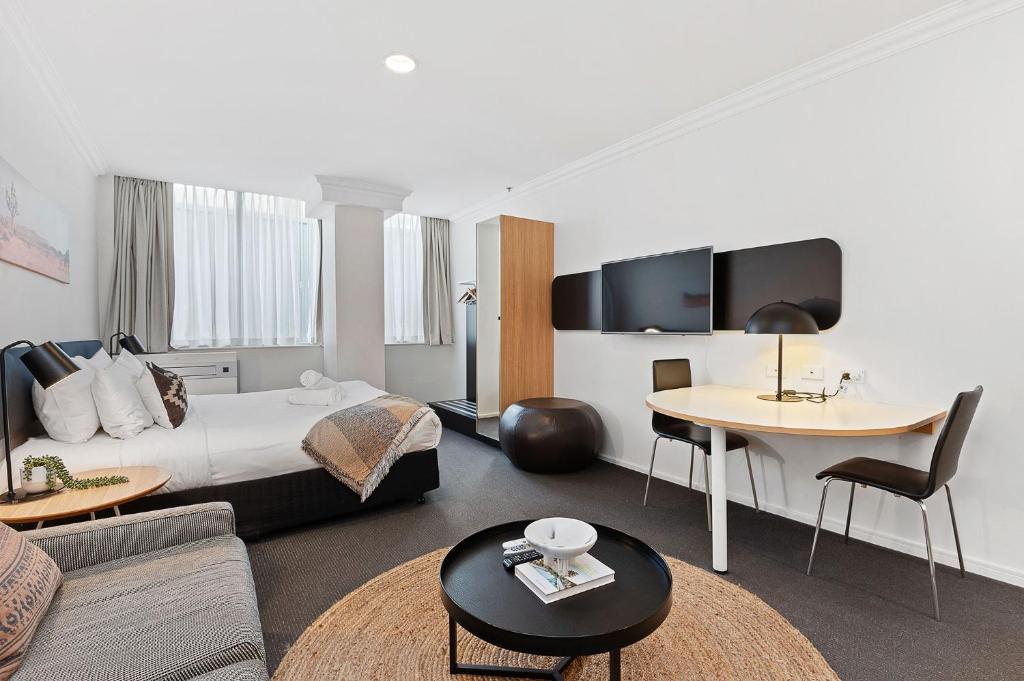 a hotel room with a bed and a table at Best Location Downtown Perth in Perth