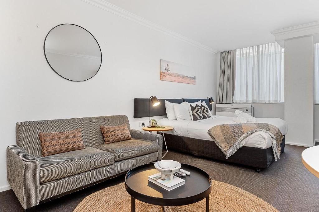 a living room with a bed and a couch at Best Location Downtown Perth in Perth