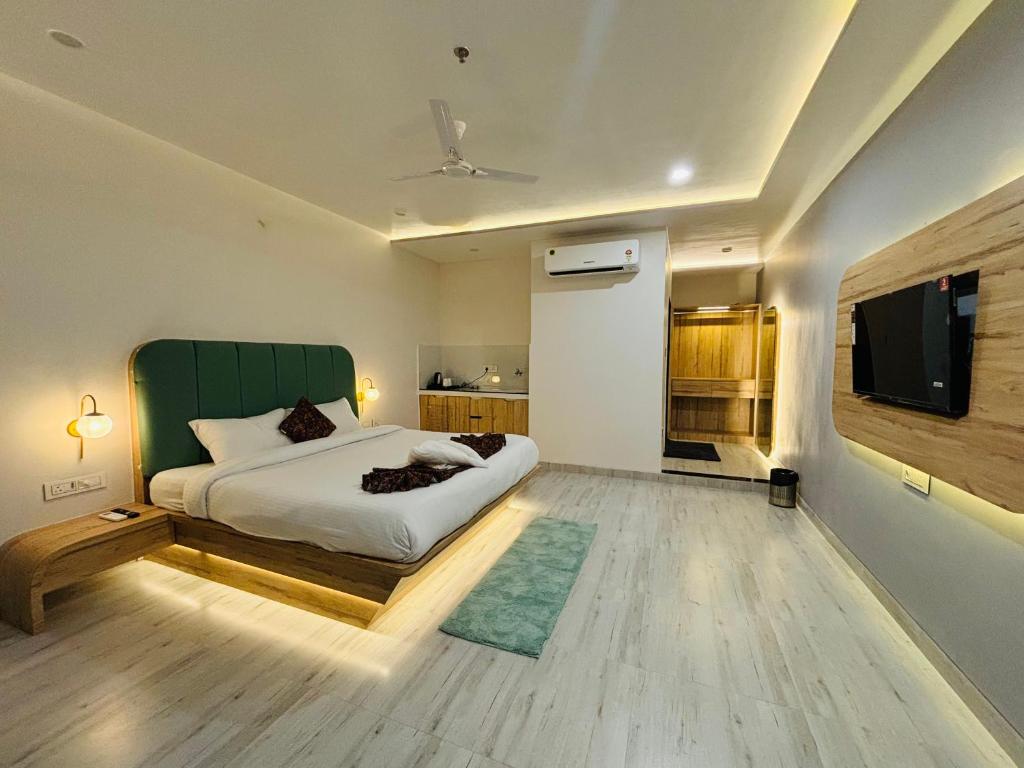 a bedroom with a bed and a flat screen tv at The Lavish Stay in Varanasi