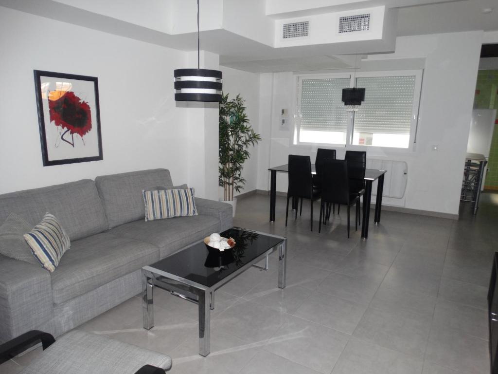 sala de estar con sofá y mesa en Málaga Apartamentos - Nuño Gómez, 24, en Málaga