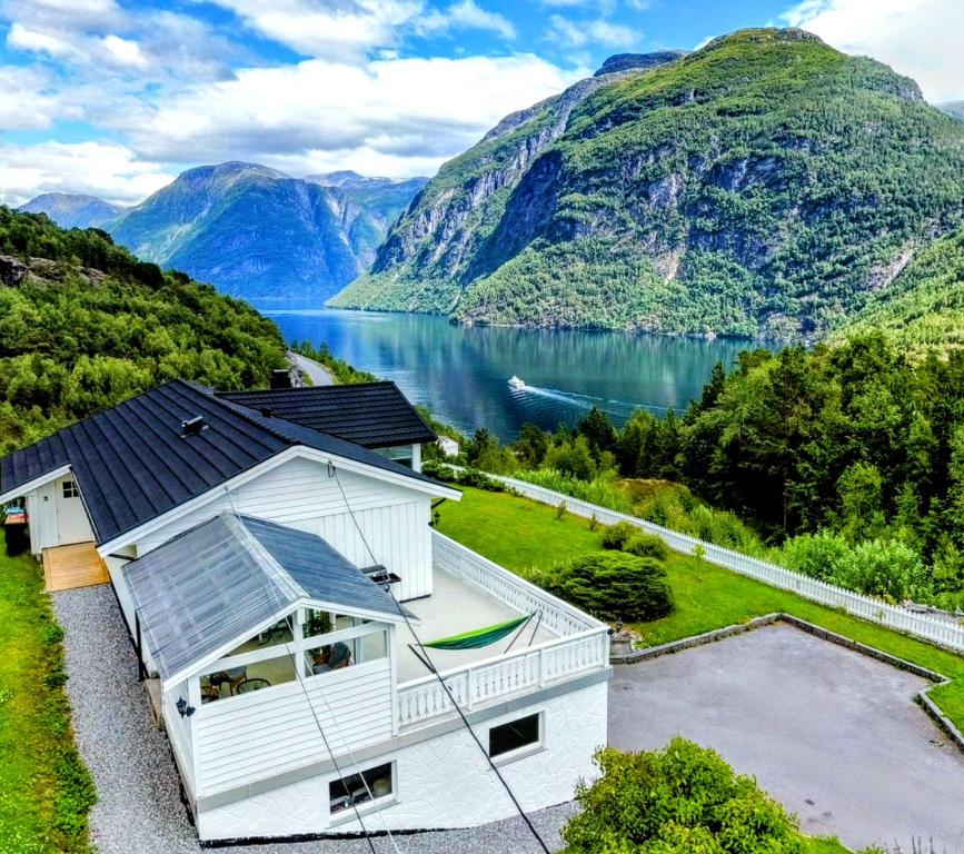 a house with a view of a lake and mountains at Fjellhagen - Geirangerfjord view in Hellesylt