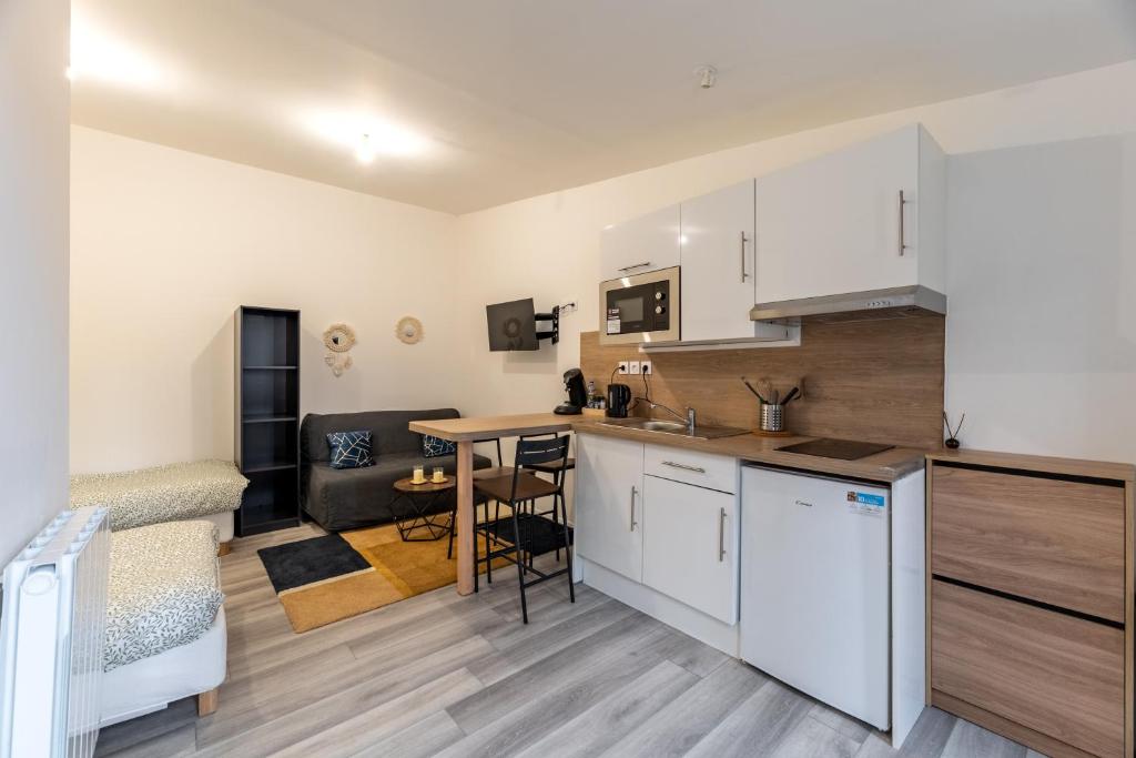 Il comprend une cuisine et un salon avec une table. dans l'établissement Studio 25m2 rénové, tout confort, à Le Petit-Quevilly