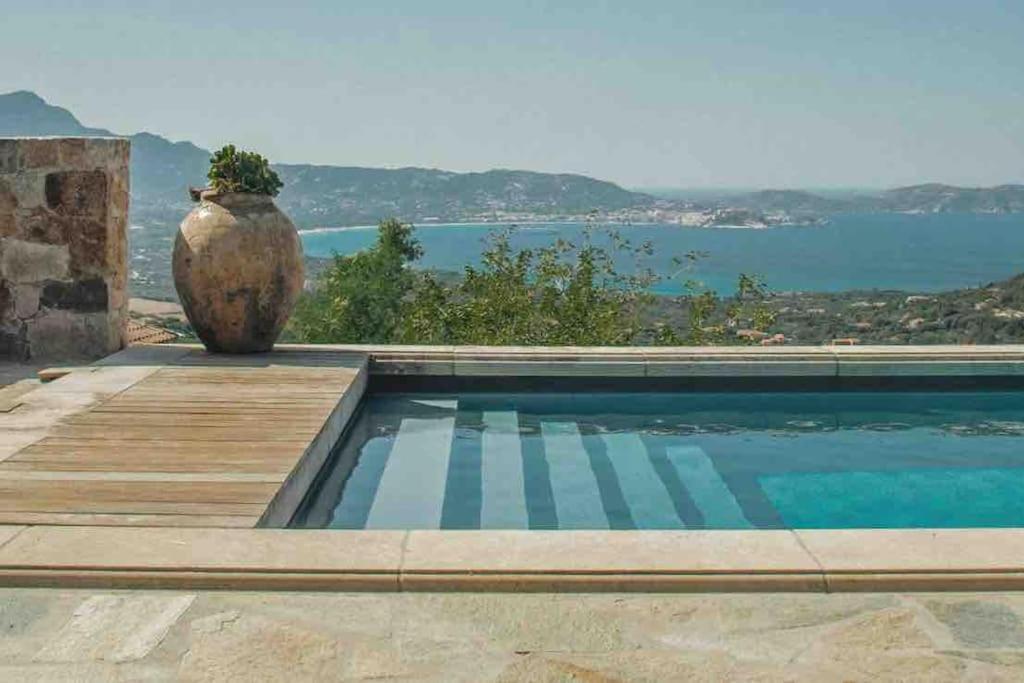 ein Swimmingpool mit einer Vase an der Seite eines Hauses in der Unterkunft Luxury house with pool - Lumio in Lumio