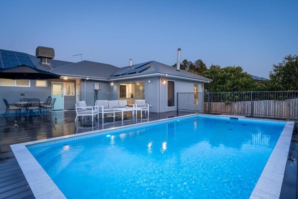 a large blue swimming pool in front of a house at Casa Estiva in Rye