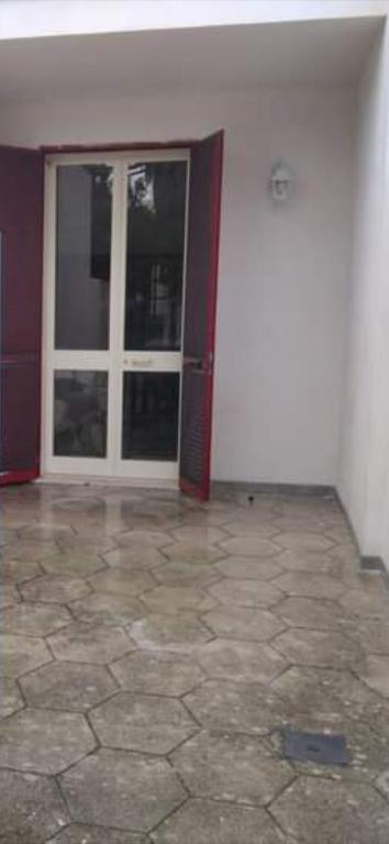 an empty room with a door and a tile floor at STELLA SUL MARE in San Foca