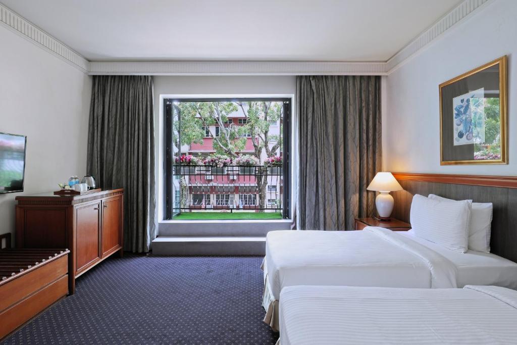 Postel nebo postele na pokoji v ubytování The Jesselton Hotel