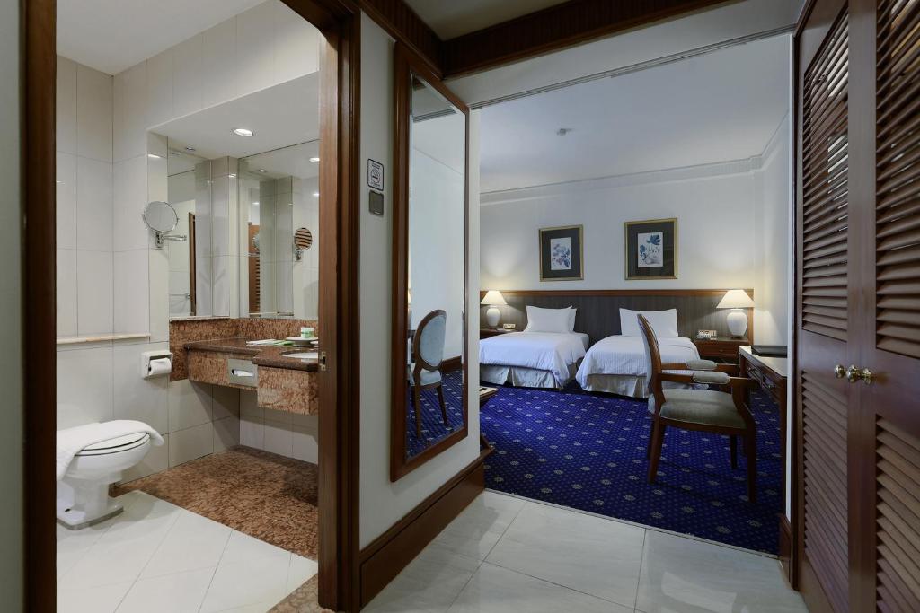 Postel nebo postele na pokoji v ubytování The Jesselton Hotel
