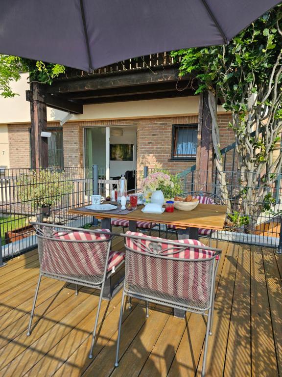 a table and chairs with an umbrella on a deck at Ferienwohnung Sieben Raben in Neustadt an der Weinstraße