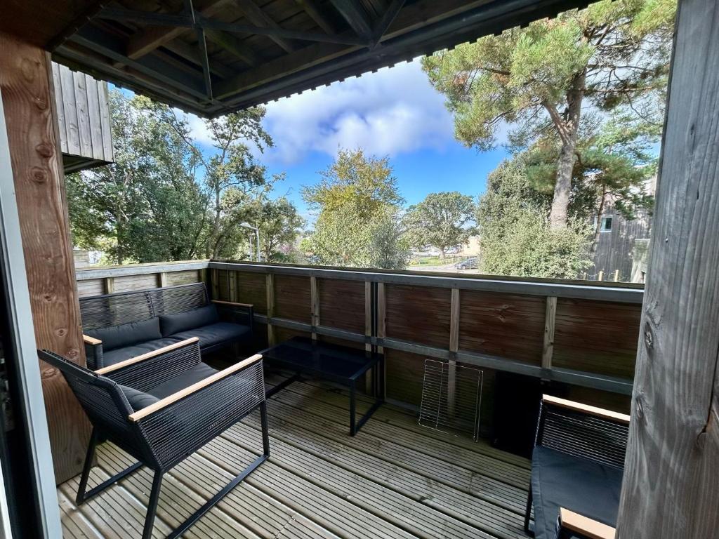 une terrasse avec des chaises et un banc dessus dans l'établissement Ma Mika - Appartement proche mer, à Saint-Nazaire