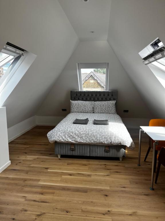 a bedroom with a bed in a attic with a window at Keysan House 1 in London
