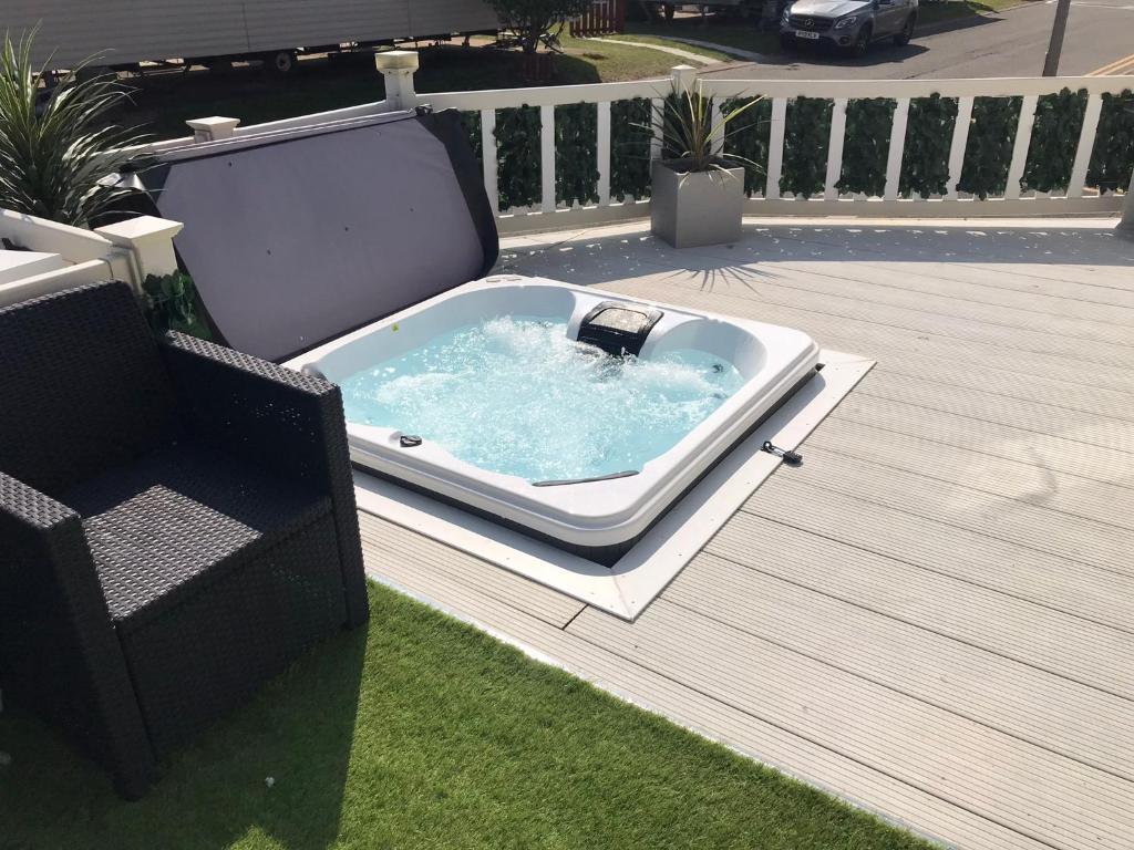 a bath tub sitting on top of a deck at Hot Tub Safari Lodge in Kinmel Bay