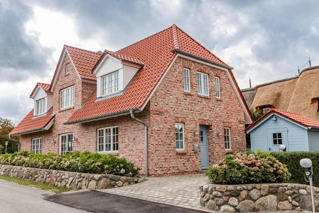 a brick house with a red roof at Landhaus Marie in Oldsum