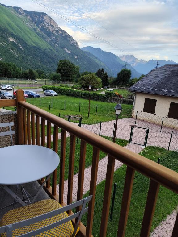 d'un balcon avec une table et une vue sur un champ. dans l'établissement Ossau T2 5 personnes tt confort climatisation piscine linge de maison inclus moustiquaires vue montagne plein sud, à Bielle