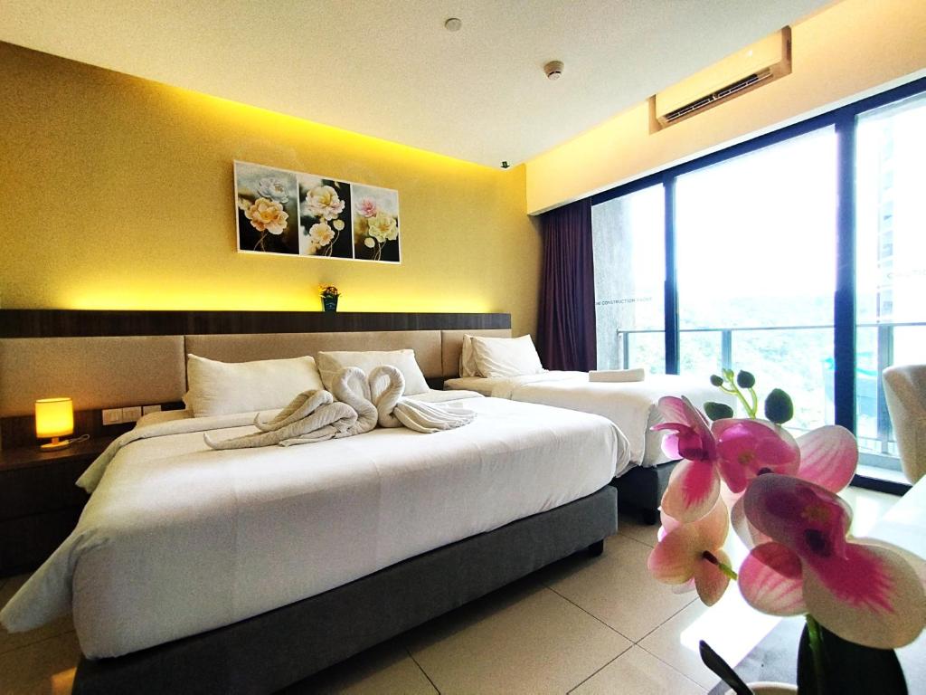 a hotel room with two beds with towels on them at Genting SmokyStayCationHut AT Ion Delemen in Genting Highlands