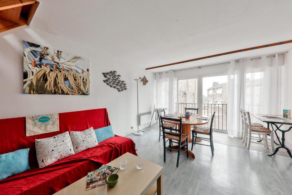 un salon avec un canapé rouge et une table dans l'établissement Appart à 100m des plages du Fogeo et Kerjouanno, à Arzon