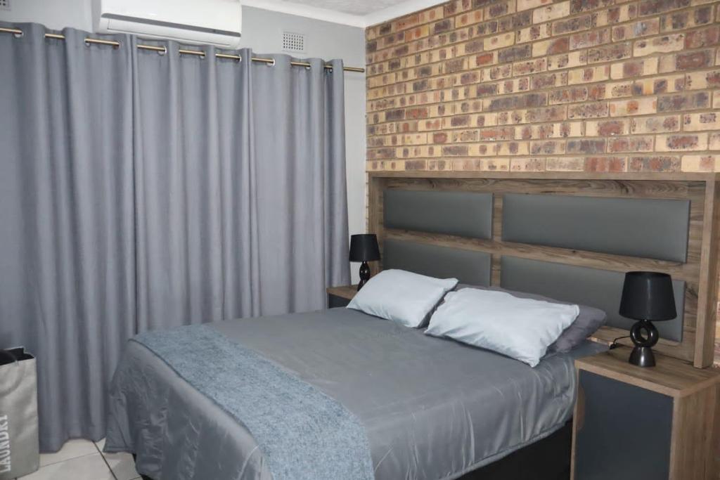 a bedroom with a brick wall and a bed at Flamboyant Apartments in St Lucia