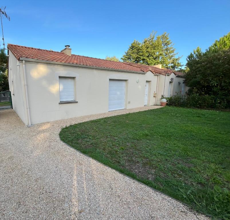 un garage blanc avec une pelouse dans l'établissement La plage - Les pins ! à 300 m de la plage, à Saint-Brévin-les-Pins