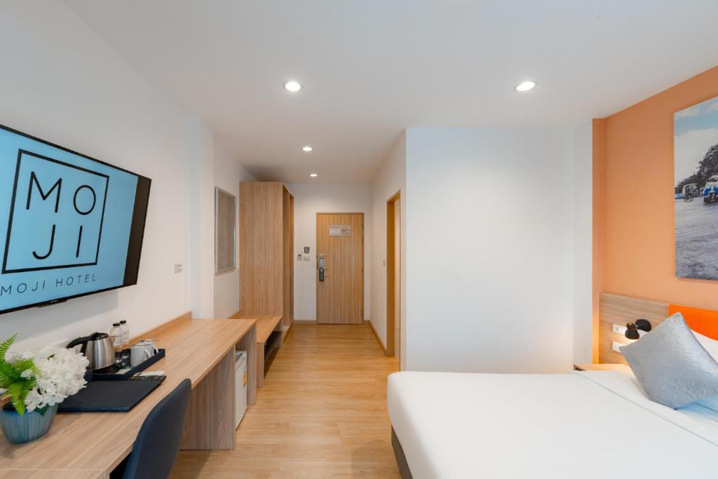 A room view focused on the desk, beverage setup, wardrobe and entry corridor.
