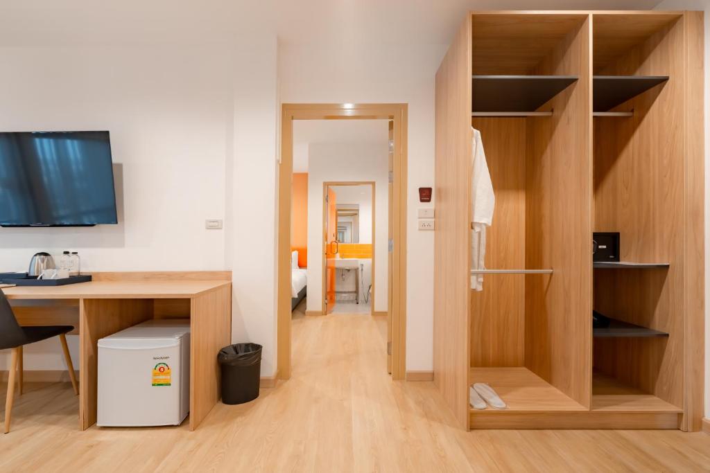 The desk and open wardrobe viewed together across the room entry.