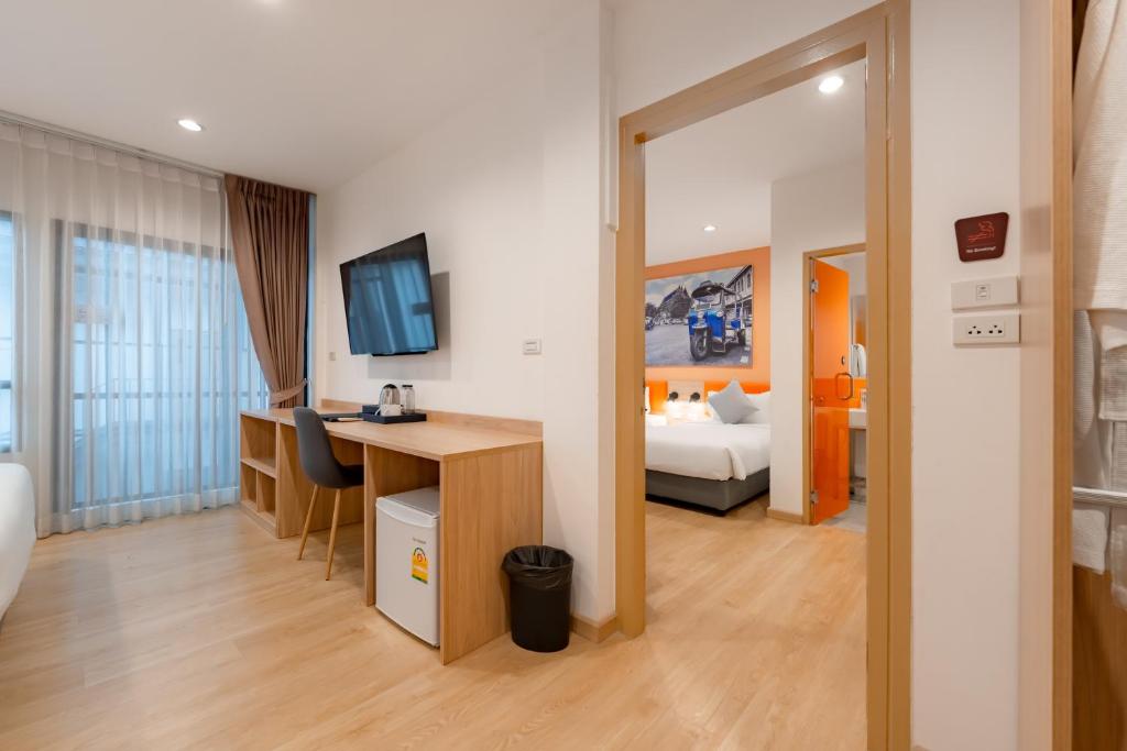 A compact in-room work area beside the window, with a desk, chair and minibar.