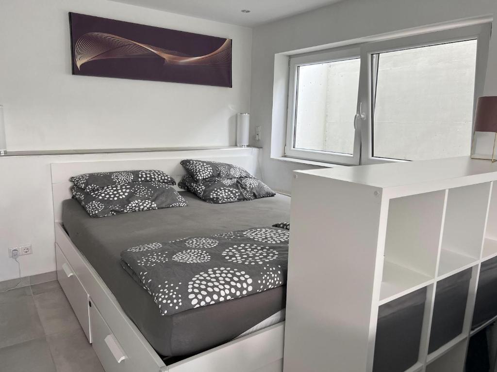 a bedroom with a bed with pillows on it at Willkommen in Dagersheim bei Böblingen! Gemütliches 1 Zi Appartement zum Wohlfühlen in einem angenehmen Umfeld! in Böblingen