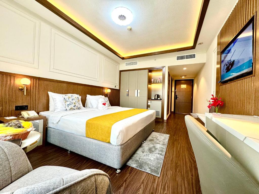 a bedroom with a large bed and a living room at Fortune Plaza Hotel, Dubai Airport in Dubai