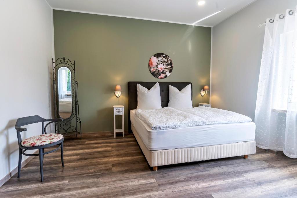 Un dormitorio con una cama, un espejo y una silla. en Flora Comfort Inn, en Oberhausen