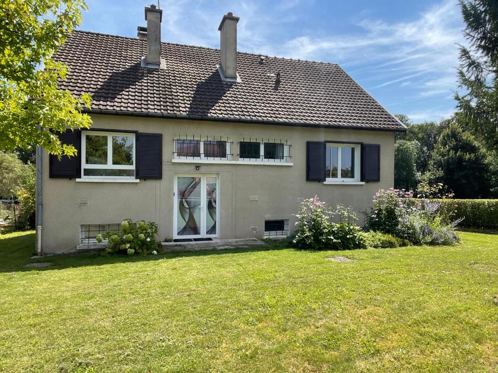 une maison avec des volets bleus et une cour dans l'établissement Maison de campagne en Champagne, à Coupéville